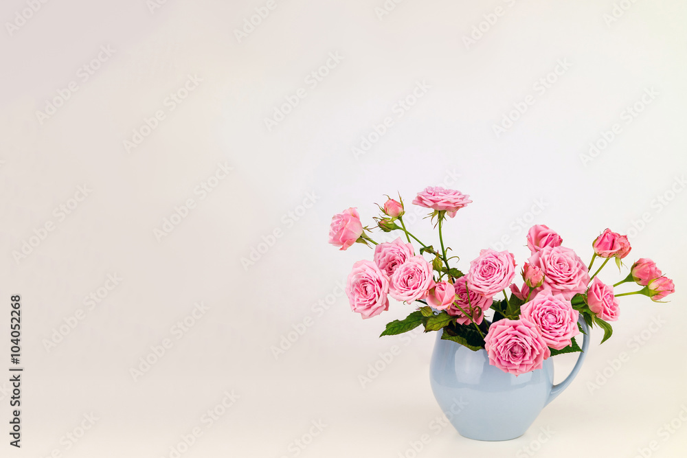 Pink flowers in blue jug. Roses in jug. Pink flowers in blue jug. Roses in jug.
