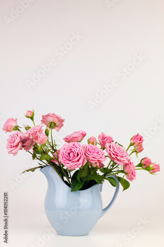 Pink flowers in blue jug. Roses in jug. © perekotypole