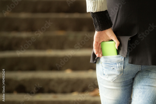 Girl taking cellphone out of her pocket.