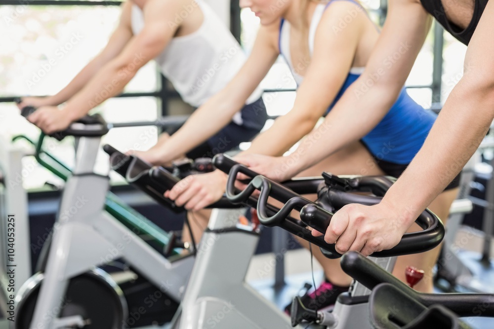 Fit group of people using exercise bike together Fit group of people using exercise bike together
