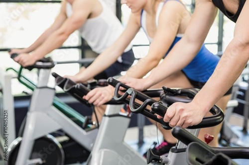 Fit group of people using exercise bike together