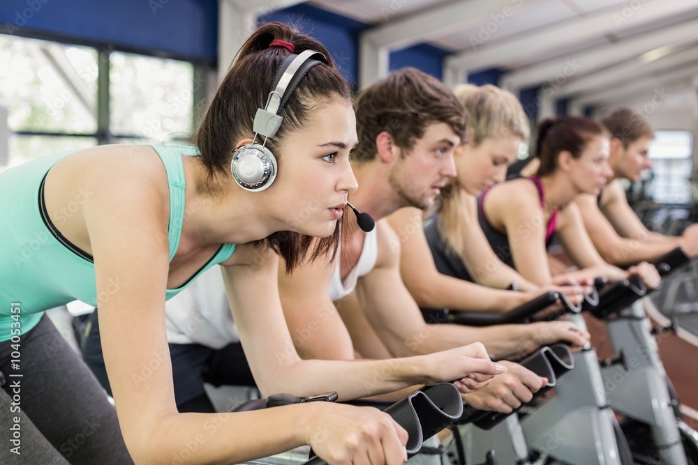 Fit group of people using exercise bike together Fit group of people using exercise bike together