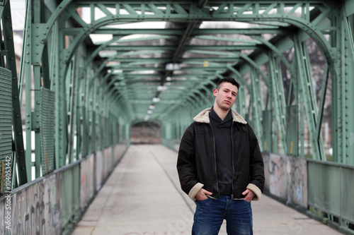 Attractive young man wearing leather jacket on the street