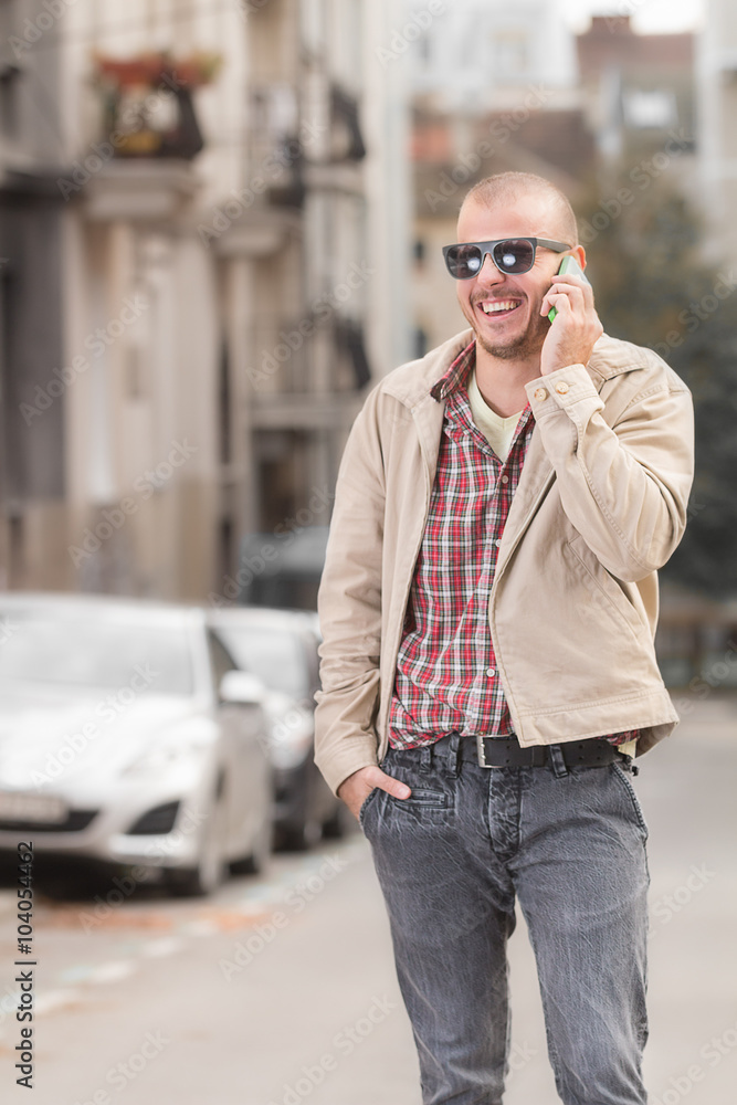 Fototapeta premium Urban guy using cellphone outdoors.
