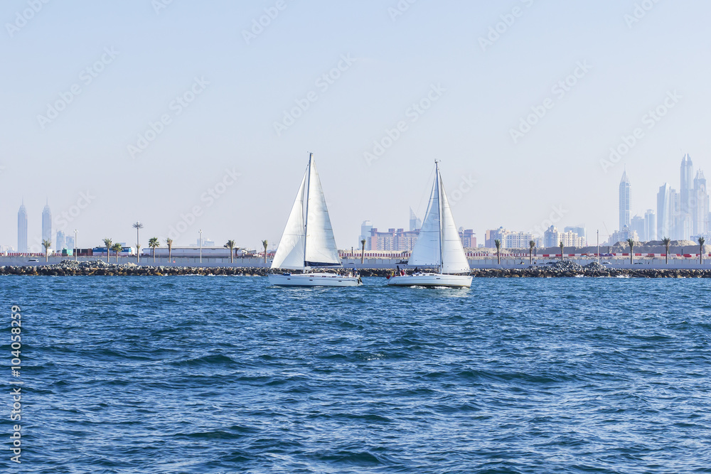 background seascape two sailboat met in the Gulf opposite the Dubai Marina in Dubai