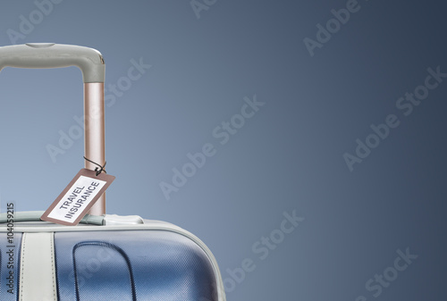 Foto Travel insurance label tied to a suitcase.
