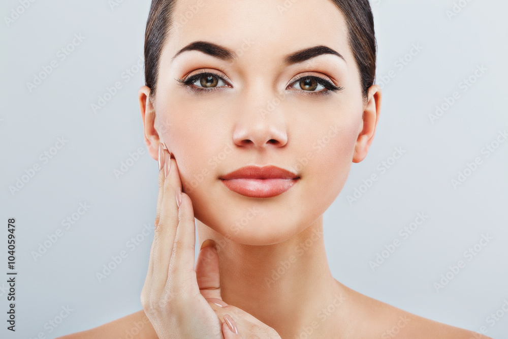 Fototapeta premium Beautiful girl with dark hair at gray studio background