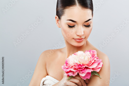 Attractive girl wearing white rowel and holding flower