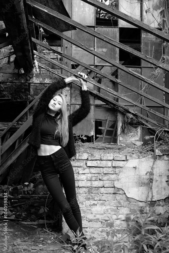 Beautiful young girl posing near the wall of old building Beautiful young girl posing near the wall of old building