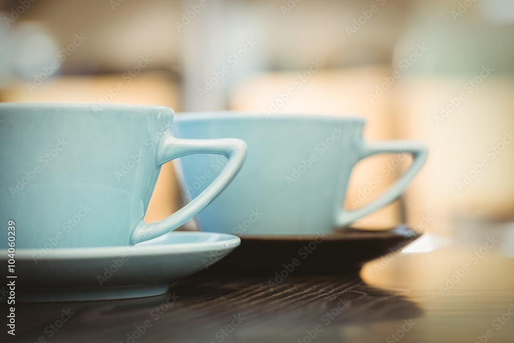 Cup of cappuccino with coffee art on wooden table Cup of cappuccino with coffee art on wooden table