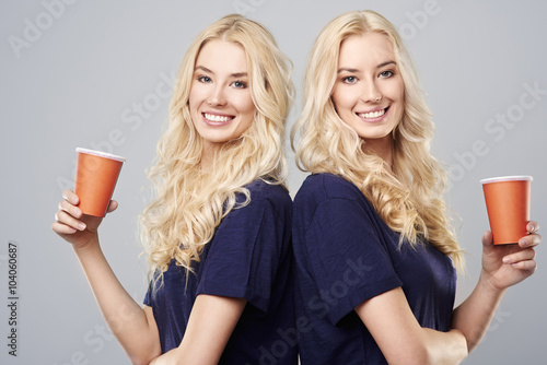 Girls with cups standing back to back. photo