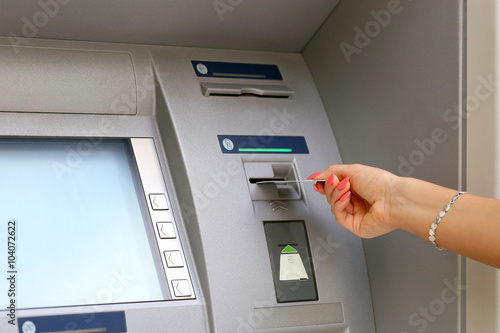 woman hand inserting credit card to ATM