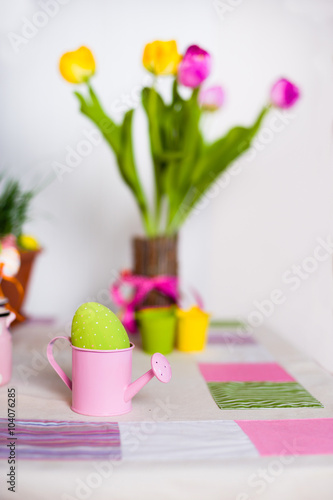Colored speckled egg in a small pink watering pot