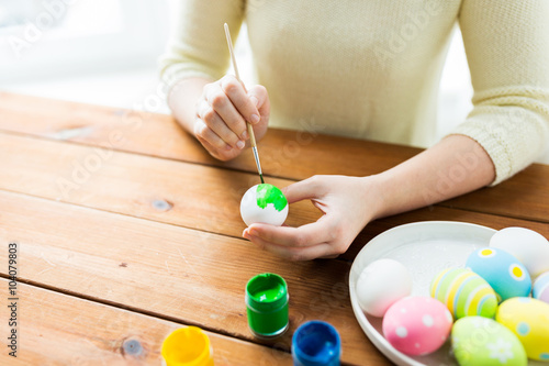 close up of woman hands coloring easter eggs