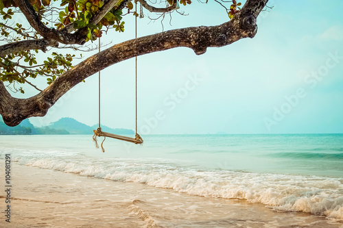 Wooden swing on  tropical beach photo