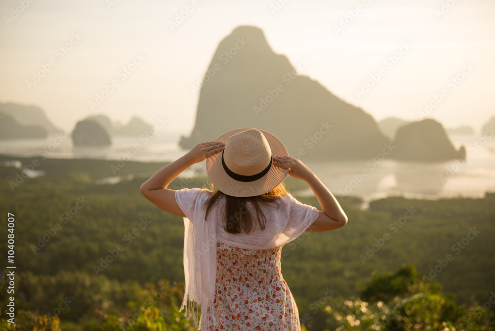 Young lady is watching sunrise at new unseen place name 