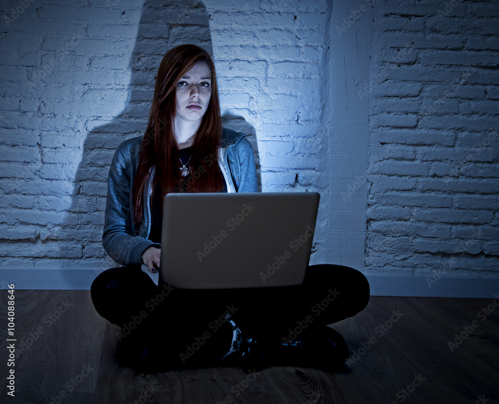 scared female teenager with computer laptop suffering cyberbullying and ...
