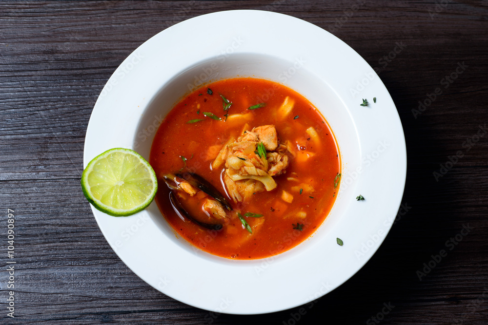 Delicious soup with mussels on black background Delicious soup with mussels on black background