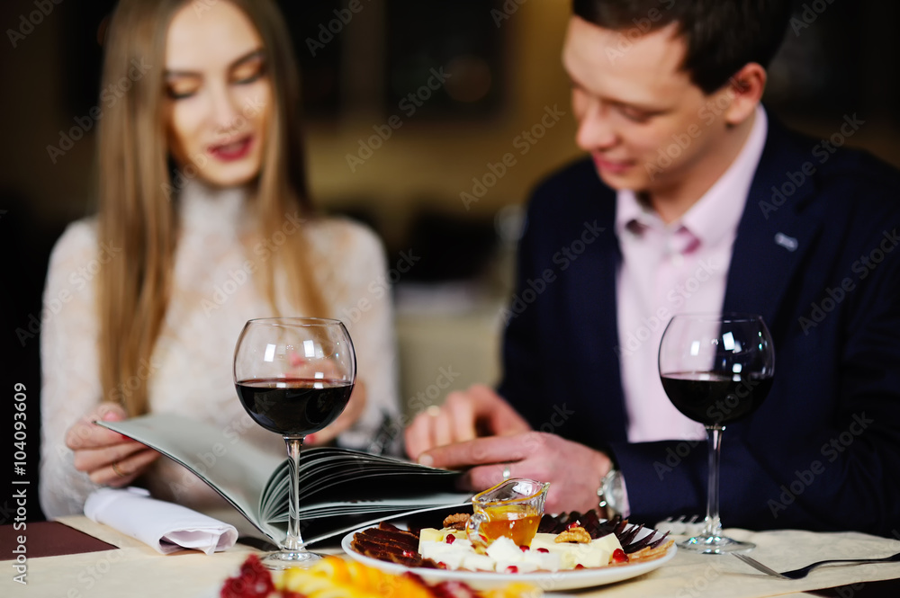 guy with a girl in a restaurant choose dishes from the menu