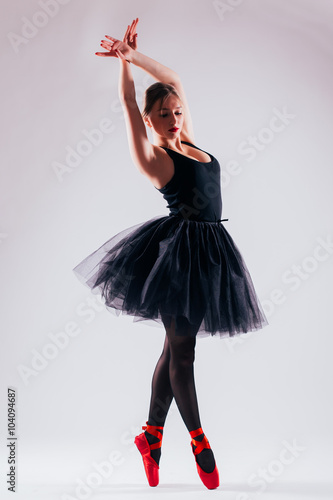 one caucasian young woman ballerina ballet dancer dancing with tutu in silhouette studio on grey background