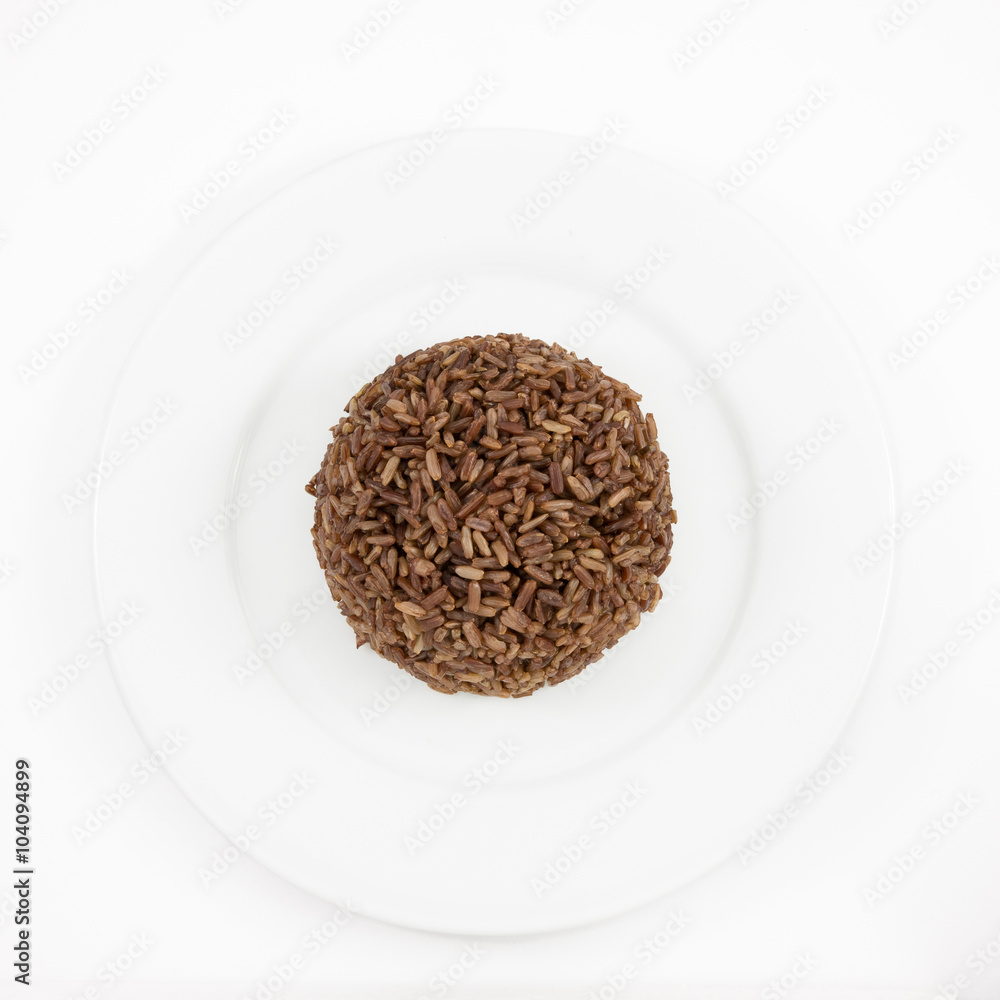 The cooked dark brown rice on the white plate for good healthy. The cooked dark brown rice on the white plate for good healthy.