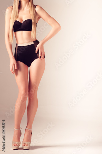 Sexy young blonde woman posing in a bikini.Beautiful perfect figure. Studio portrait.