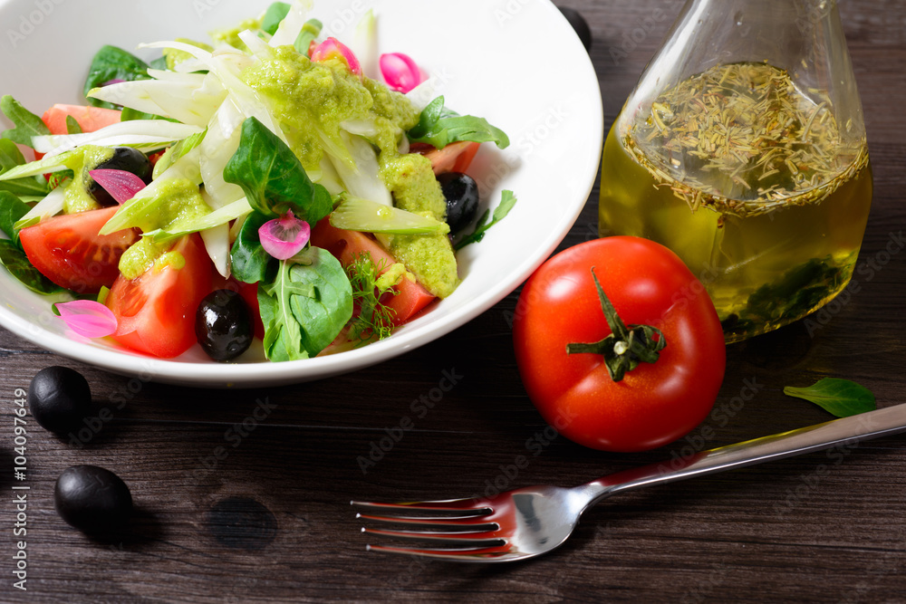 salad on plate, next tomato and fork