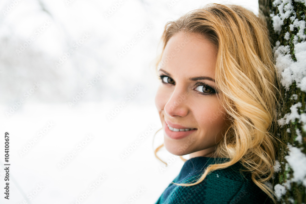 Fototapeta premium Smiling face of blond woman outside in winter nature