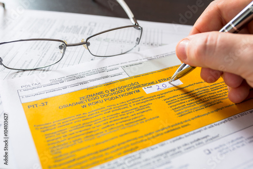 Polish tax form PIT-37 concept with money, pen and glasses