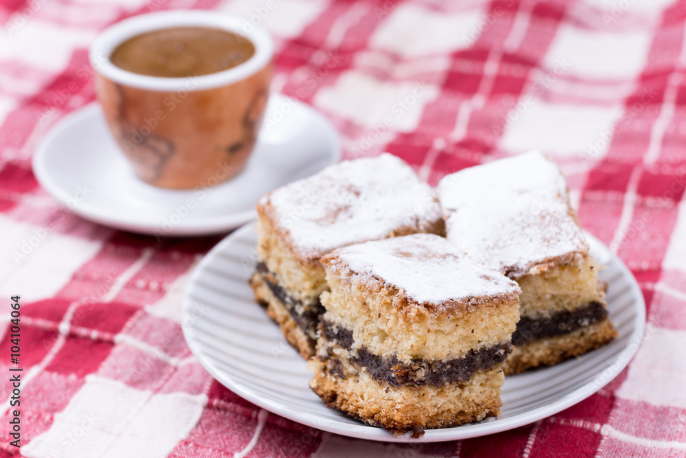 Cup of coffe with cakes on the plate over red and white tableclo Cup of coffe with cakes on the plate over red and white tableclo