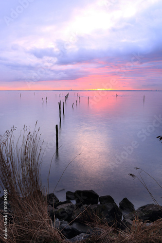 rode zonsopkomst boven een verstild Markermeer  kleurt een deel van de lucht