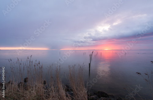 rode zonsopkomst boven een verstild Markermeer  kleurt een deel van de lucht