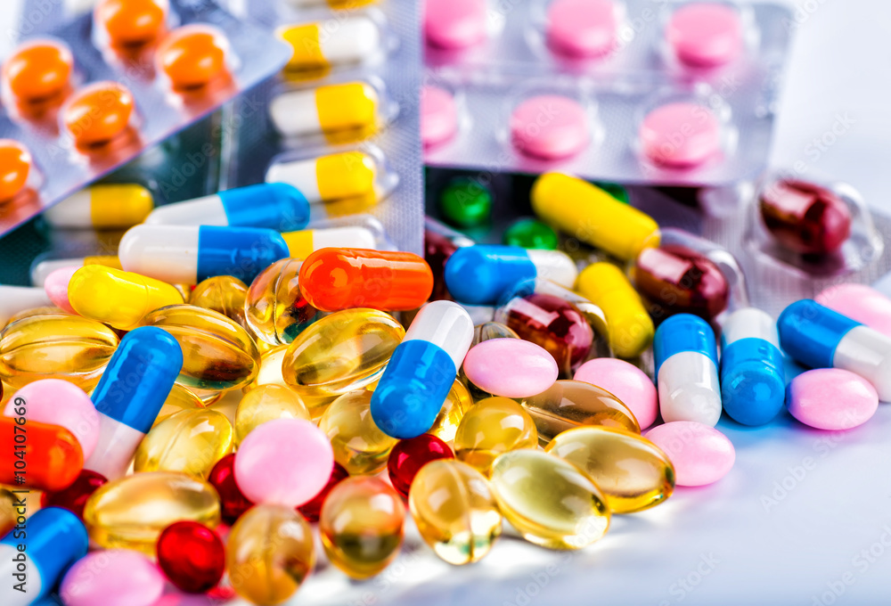 Medications tablets and capsules in a beaker Medications tablets and capsules in a beaker