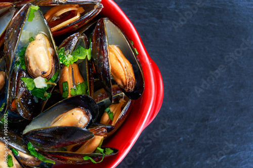 Mussels  garlic butter sauce in Red bowl. photo