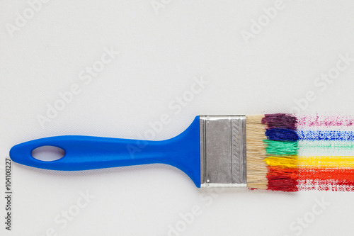 Paintbrush with blue handle and multicolor rainbow brush strokes