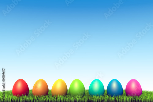 Color eggs row in the green grass Easter background.