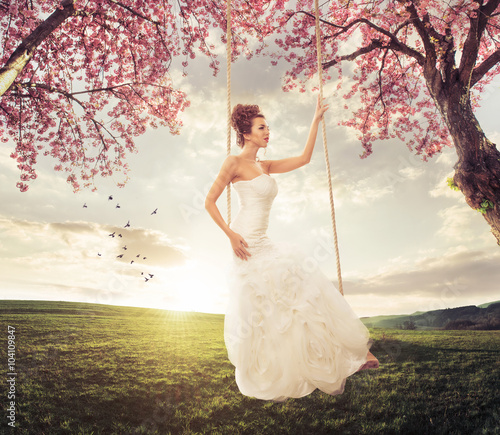 Beautiful Bride swing in the spring meadow
