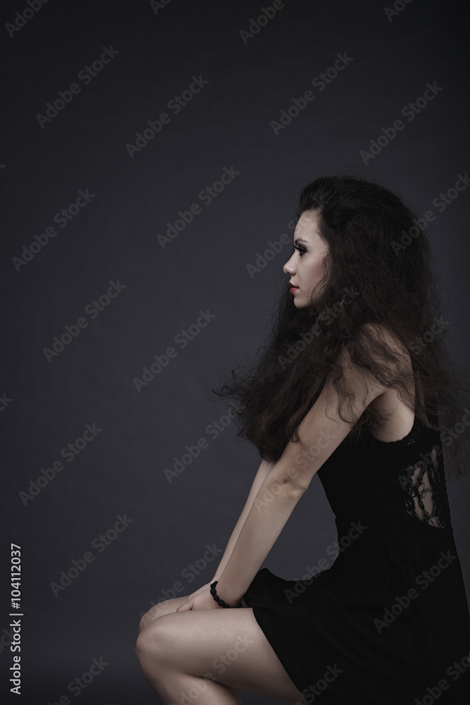 High fashion sensual girl in the black dress in the studio profile shot