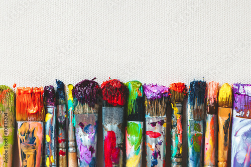 Row of artist paintbrushes closeup on artistic canvas. photo