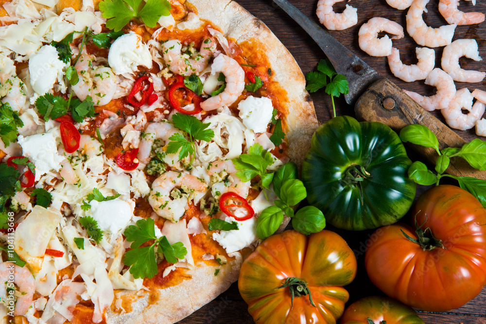 A hand stretched,wood fired pizza base topped with tomato and fresh