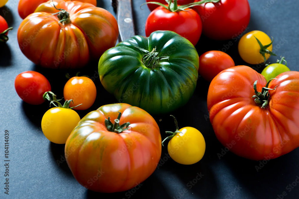 unique colorful ripe tomatoes on black background. unique colorful ripe tomatoes on black background.