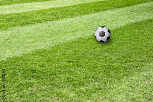 Conceptual soccer ball field background. Soccer ball waiting on sunny soccer field ground. 