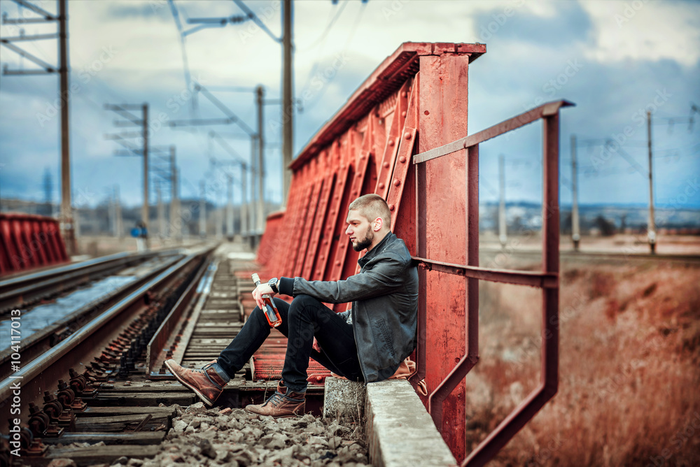Man with beard sitting on the railway