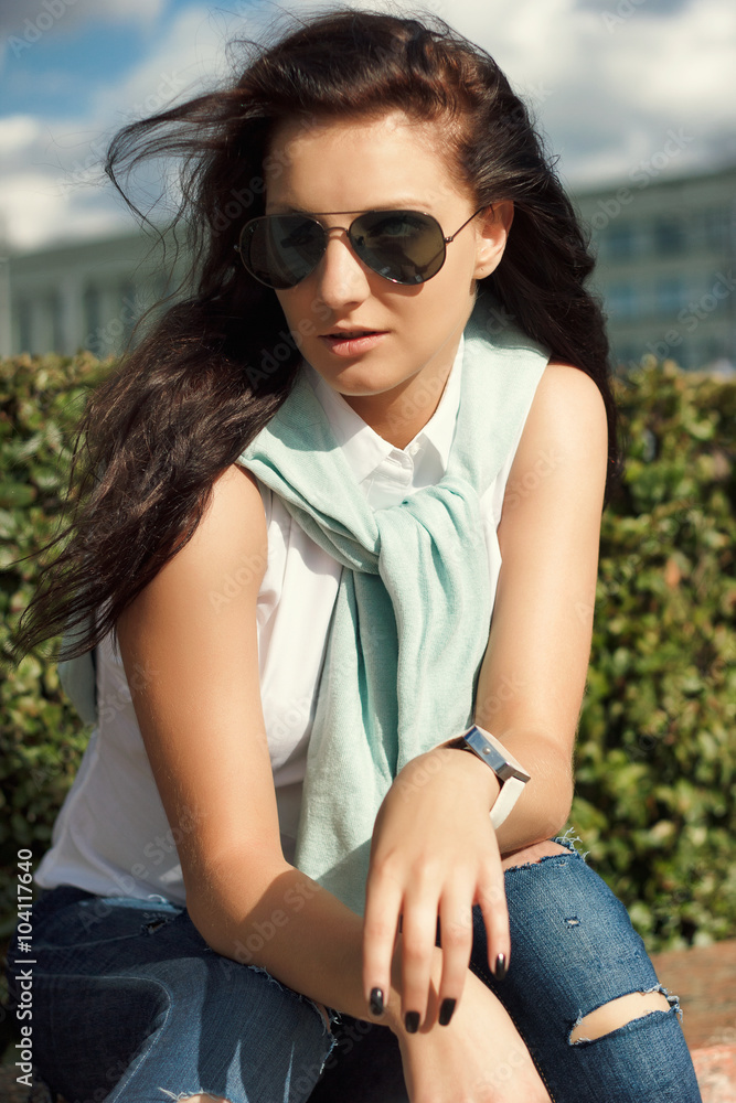 Smiling woman with long curly hair outdoors with sunny glasses Smiling woman with long curly hair outdoors with sunny glasses