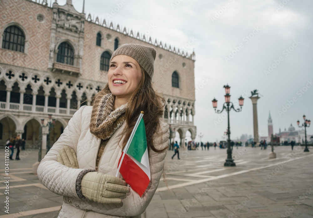 Woman tourist with Italian flag standing near Dogi Palace Woman tourist with Italian flag standing near Dogi Palace