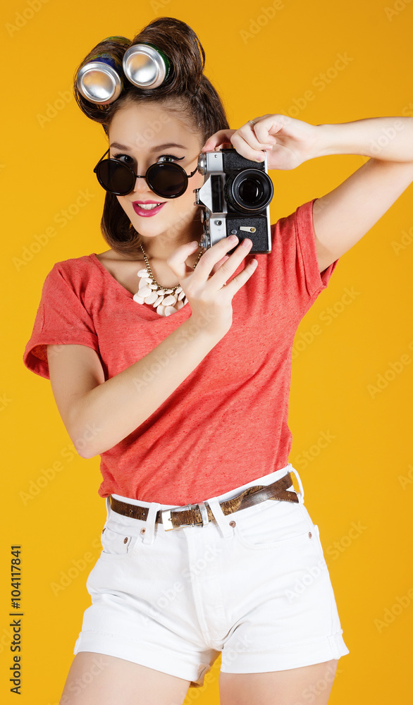 Young attractive fashionable woman with old-school camera wearing glasses Young attractive fashionable woman with old-school camera wearing glasses
