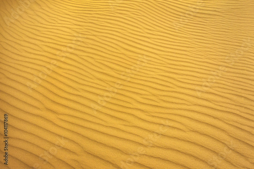 gold pattern of sand on the beach in summer. wave of sand