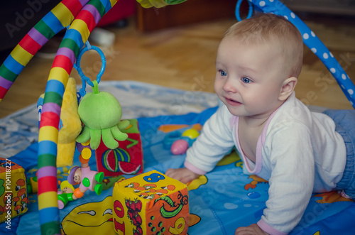 Baby boy crawling on colorful playmat