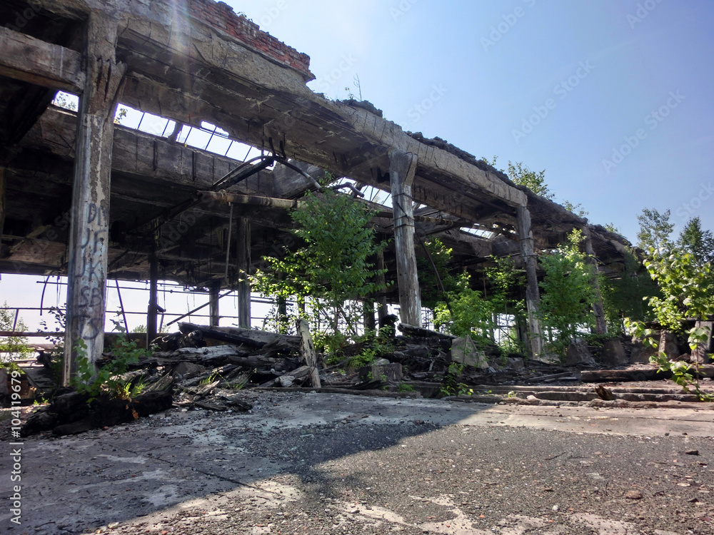 Abandoned industrial factory warehouse exterior crumbling - landscape color photo