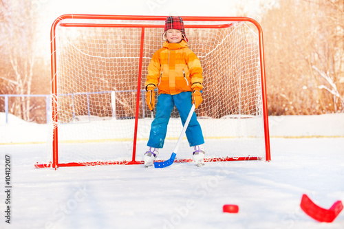 Photography Little boy play ice hockey outside on winter day